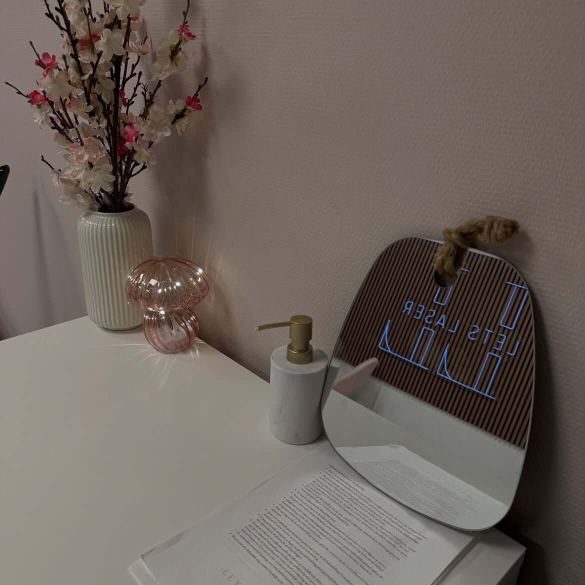 Interieur van de praktijk met het logo van Let's Laser in de spiegel